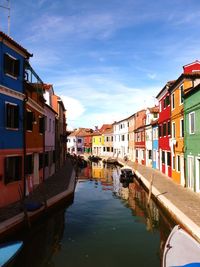 Boats in canal along buildings