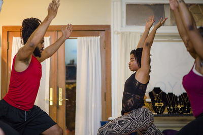 A female yoga instructor leads students in relaxation techniques