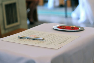 Close-up of pen and document on table during wedding