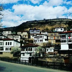 Houses on mountain against cloudy sky