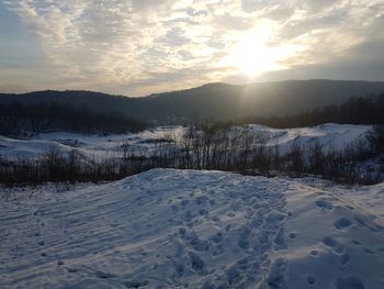 Scenic view of snowy landscape against sky during sunset