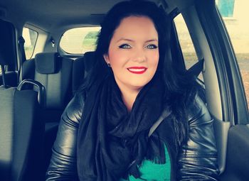 Portrait of young woman sitting in car