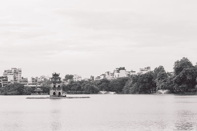 Scenic view of lake by buildings against sky