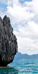 Rock formation in sea against sky