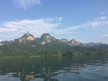 Scenic view of lake by trees against sky