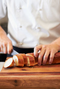 Midsection of man preparing food on cutting board