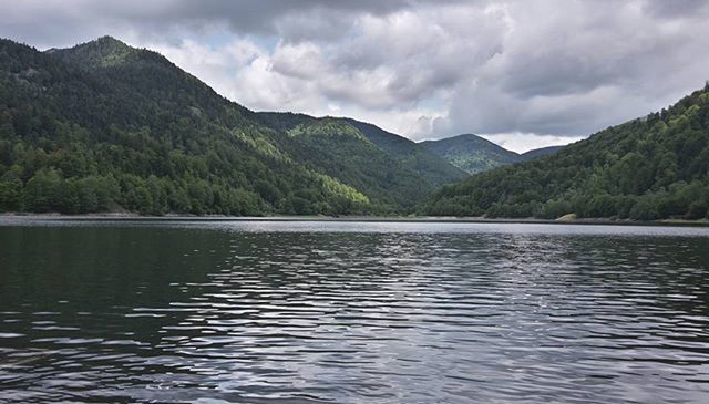 mountain, water, tranquil scene, lake, sky, scenics, tranquility, waterfront, mountain range, beauty in nature, cloud - sky, cloudy, tree, nature, cloud, reflection, idyllic, river, rippled, non-urban scene