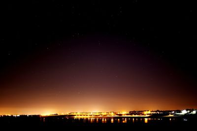 Illuminated city against sky at night