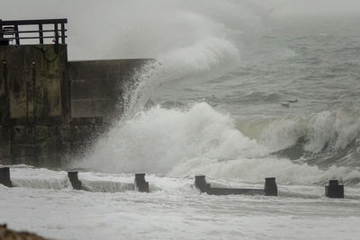 Waves splashing on shore against sea