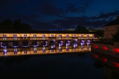 Row of boats moored in lake against sky at night