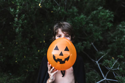 Close-up of hand holding pumpkin at halloween