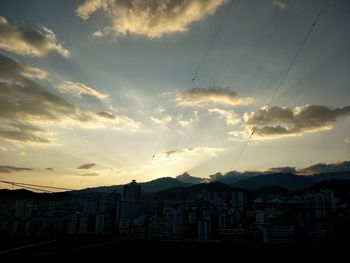 Silhouette buildings against sky at sunset