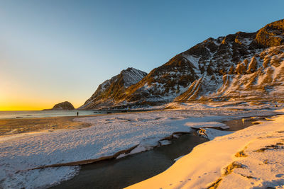 Scenic view of snowcapped mountains against clear sky during sunset