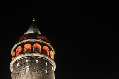 Low angle view of illuminated building against sky at night