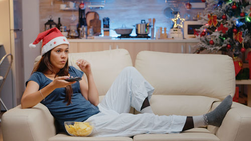 Woman sitting on sofa at home