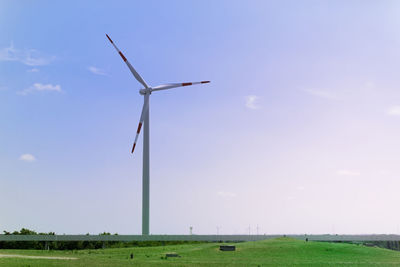 Windmill on field against sky
