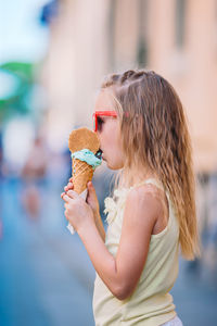 Young woman blowing ice cream cone