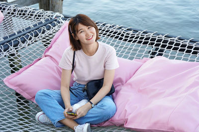 Portrait of smiling young woman sitting on seat