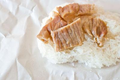 Close-up of rice and meat in paper