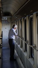 Side view of a man standing in corridor