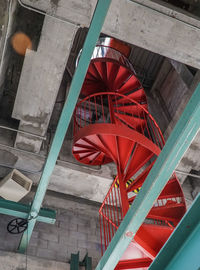 Low angle view of red machinery on staircase in abandoned building