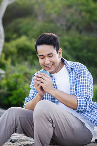 Side view of young man sitting outdoors