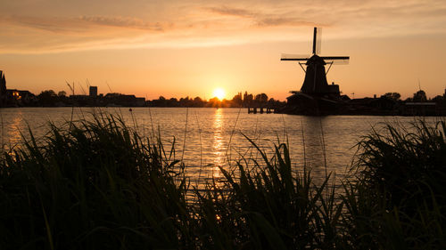 Silhouette traditional windmill against sky during sunset