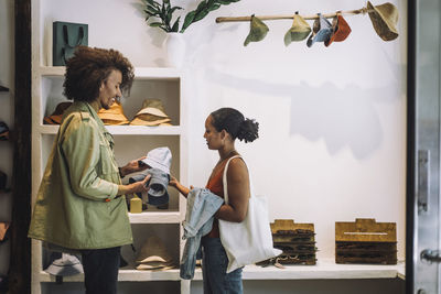 Couple buying hats while standing together at fashion boutique