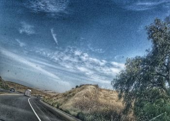 Scenic view of road against cloudy sky