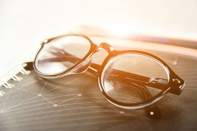 Eyeglasses on diary against gray background