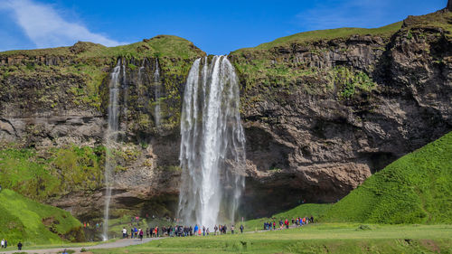 Tiny looking people reveal the size of impressive seljalandfoss waterfalls grace icelandic scenery