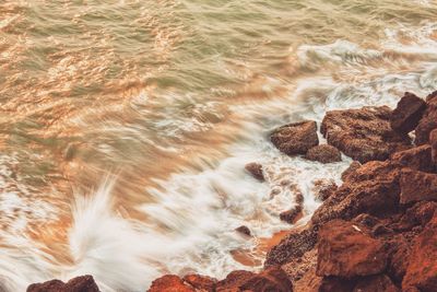 High angle view of waves breaking on rocks