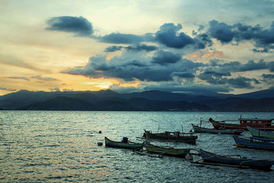 View of boats in sea against cloudy sky