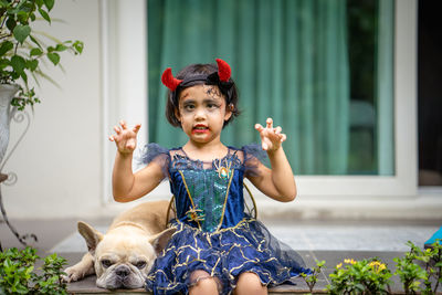 Portrait of cute girl in halloween costume with dog.