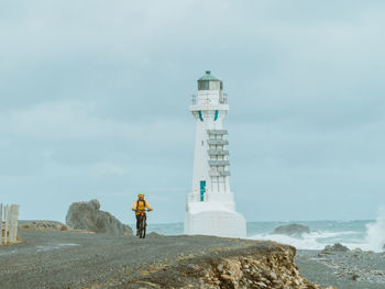 Rear view of lighthouse by sea against sky