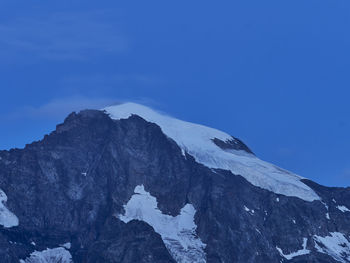 Scenic view of snowcapped mountains against clear blue sky