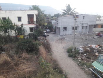 Houses by road amidst buildings in city