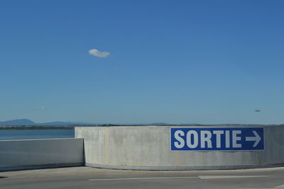 Information sign against blue sky