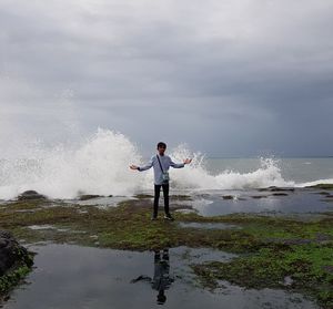 Full length of man standing on sea against sky