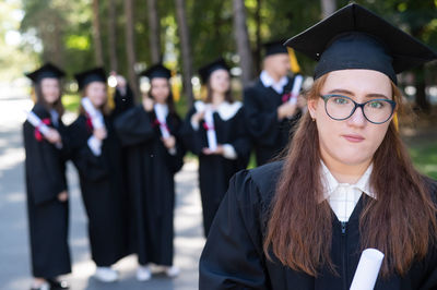 Portrait of smiling young woman wearing graduation gown