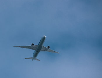 Low angle view of airplane against clear blue sky