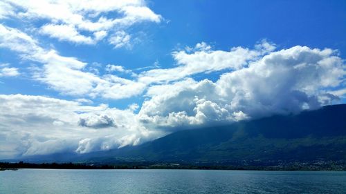 Scenic view of river against cloudy sky