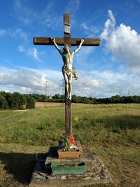 Statue on field against sky