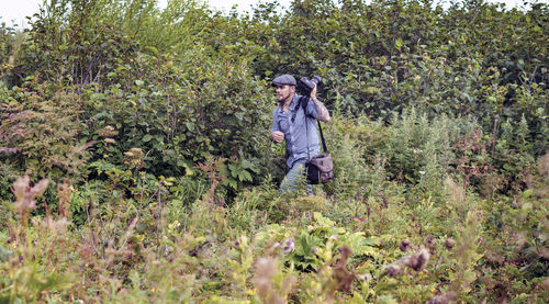 Mid adult man with camera walking in forest