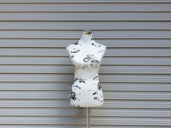 Mannequin stand against corrugated metal wall