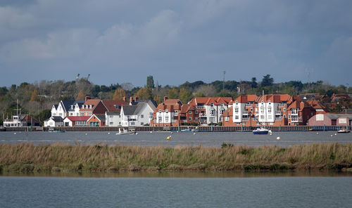 A view of houses in a riverside town against blue sky 