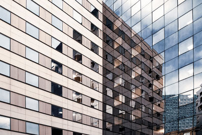 Low angle view of modern glass building in city