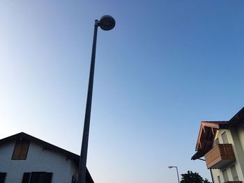 Low angle view of houses against clear blue sky