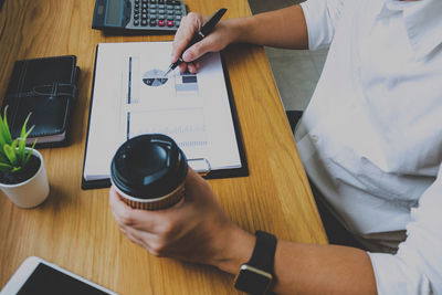 High angle view of man using mobile phone on table