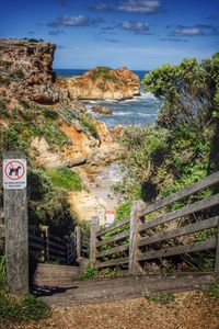 Steps leading to sea against sky